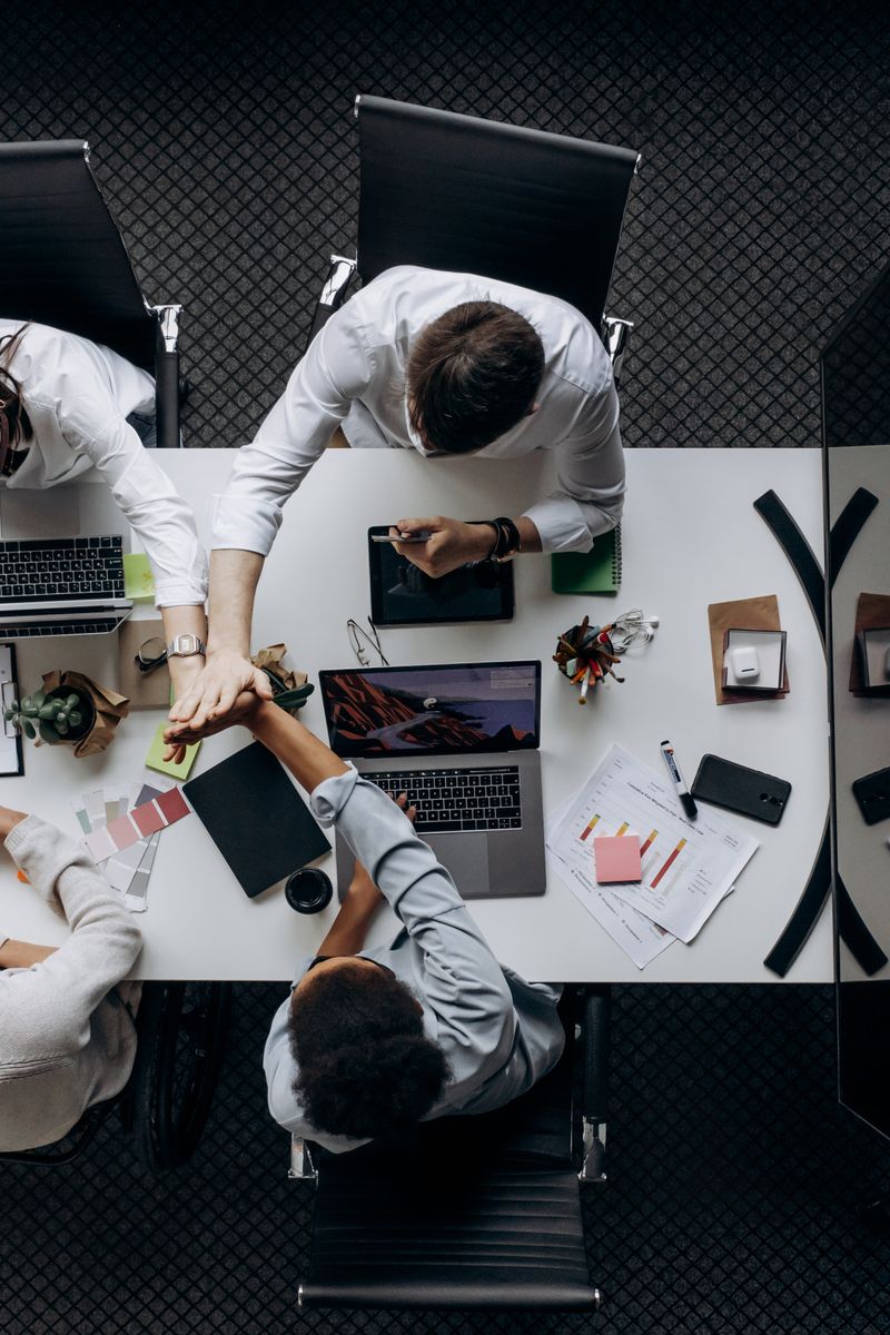 High angle view of colleagues collaborating around a conference table in a modern office setting.